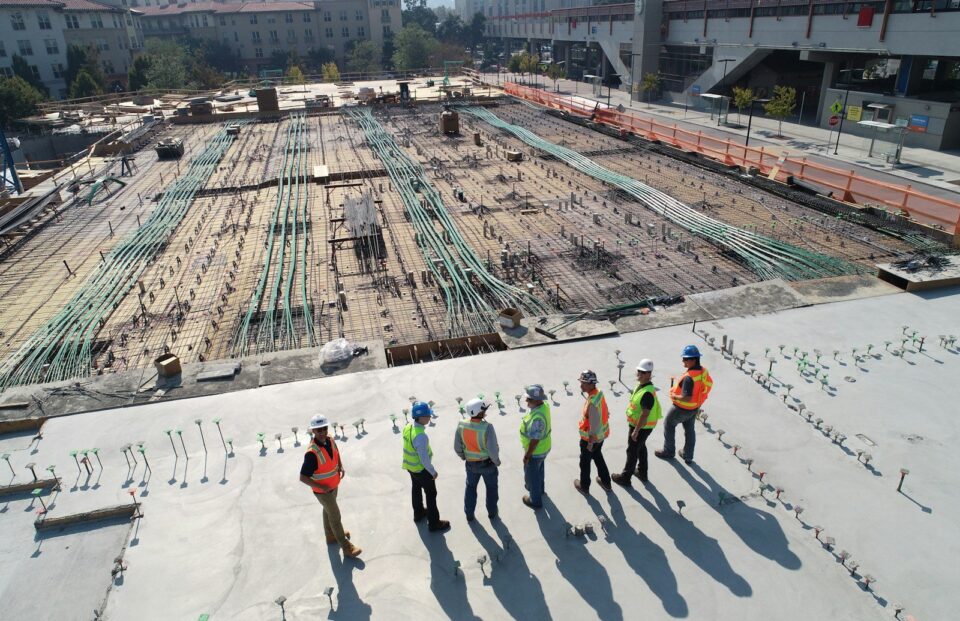 seven construction workers standing on white field